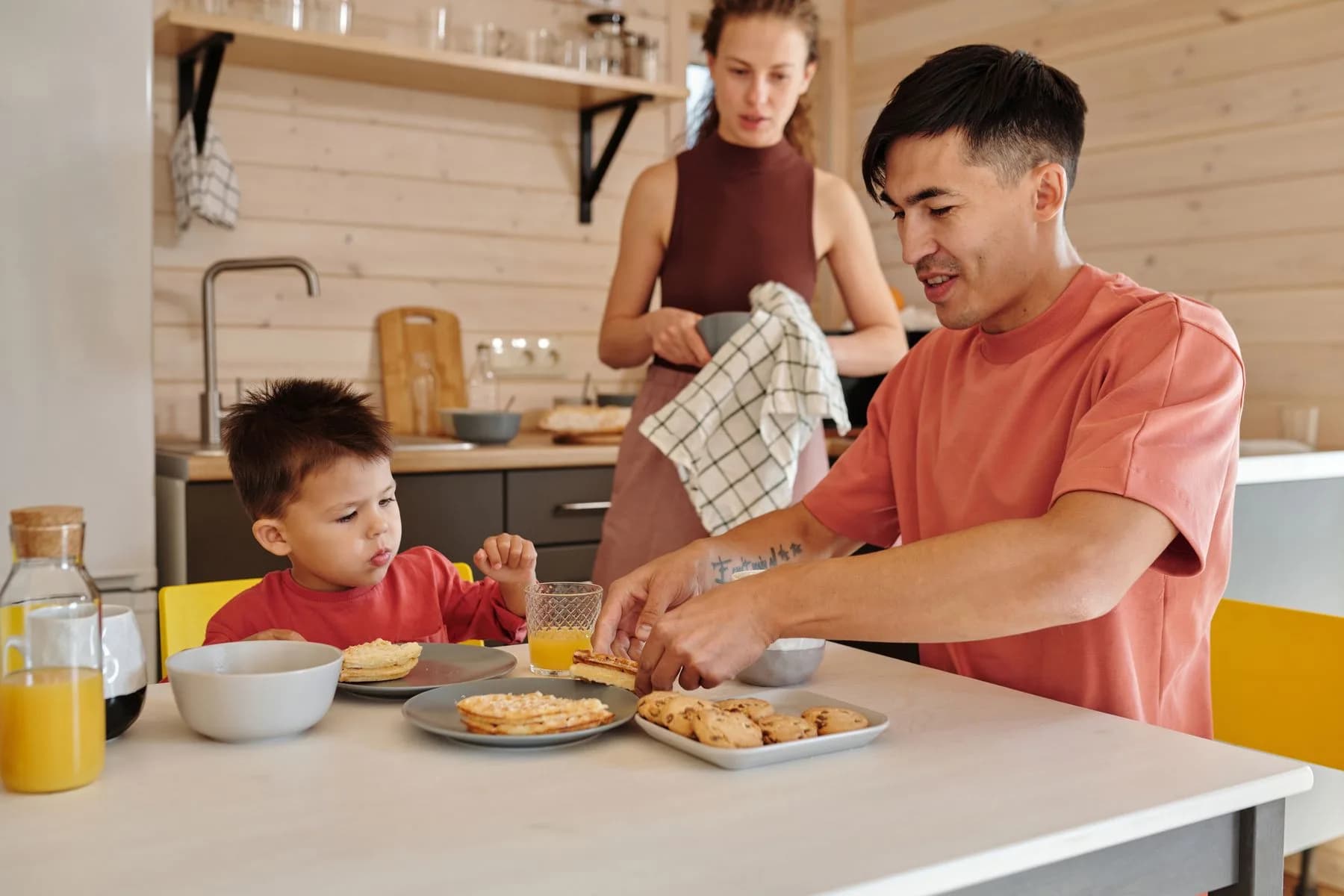 Eine Familie frühstückt gemeinsam am Küchentisch
